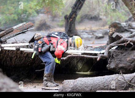 Montecito, California, USA. 10th Jan, 2018. Members of the Long Beach Search and Rescue team head into the mud and debris between Hot Springs Road and Olive Mill Road in Montecito, Calif. Heavy rain brought flash flooding and mudslides to the area in Montecito, Calif. late on Tuesday, January 9, 2018. Credit: Daniel Dreifuss/Alamy Live News Stock Photo