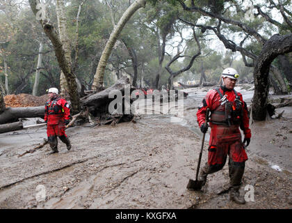 Montecito, California, USA. 10th Jan, 2018. Members of the Long Beach Search and Rescue team head into the mud and debris between Hot Springs Road and Olive Mill Road in Montecito, Calif. Heavy rain brought flash flooding and mudslides to the area in Montecito, Calif. late on Tuesday, January 9, 2018. Credit: Daniel Dreifuss/Alamy Live News Stock Photo