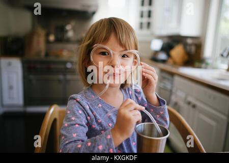 Portrait of cute girl wearing novelty glasses at home Stock Photo