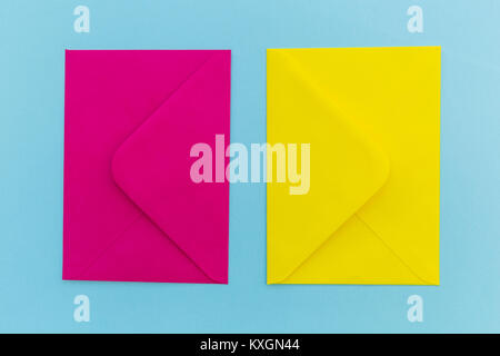 Colorful pink and yellow envelopes on bright blue background Stock Photo