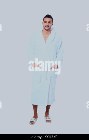 Adult man in bathrobe standing on white background. Stock Photo