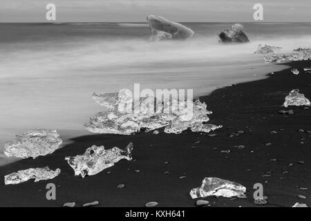 Diamond Beach, pieces of ice   on the beach with icebergs in the background Stock Photo