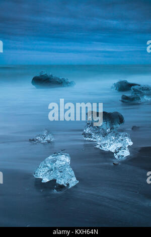 Diamond Beach, pieces of ice   on the beach with icebergs in the background Stock Photo