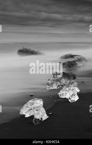 Diamond Beach, pieces of ice   on the beach with icebergs in the background Stock Photo