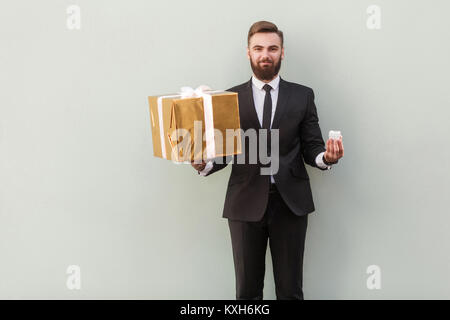 Big or small? Choise concept. Businessman holding different boxes. Studio shot Stock Photo