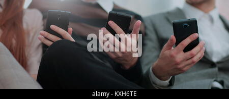 a group of young and happy managers use their phones and communicate Stock Photo