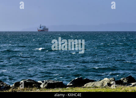 A cargo ship rides at anchor off Victoria, B.C., Canada during a gale in Juan de Fuca Strait. Stock Photo