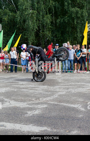 Verkhovazhye, Vologda region, Russia - August 10, 2013: Stand on the front wheel of a motorcycle in the performance of Alexei Kalinin on the motorcycl Stock Photo
