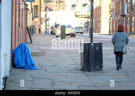 Homeless person in sleeping bag in freezing temperatures, The Calls, Leeds City Centre, Yorkshire. UK housing crisis deepens winter 2018 Stock Photo