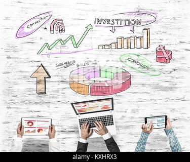 Group of three people with devices in hands working together as symbol of networking and communication Stock Photo
