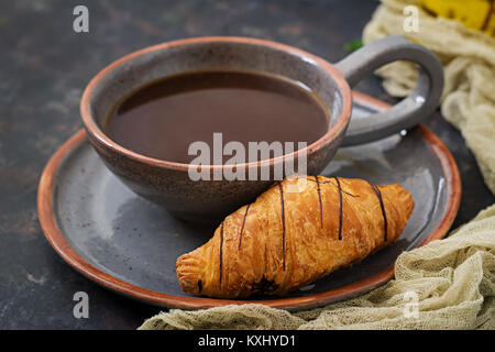 Cup of fragrant coffee and a croissant. Morning breakfast Stock Photo