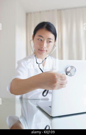 Close-up of doctor examining laptop with stethoscope at desk in clinic Stock Photo