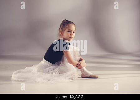 The little balerina dancer on gray background Stock Photo