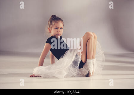 The little balerina dancer on gray background Stock Photo