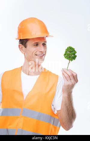 Happy nice engineer looking at the tree model Stock Photo