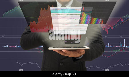 Businessman holding the taplet shown the trading graph of stock market on the virtual screen over the stock chart background, Business stock market co Stock Photo