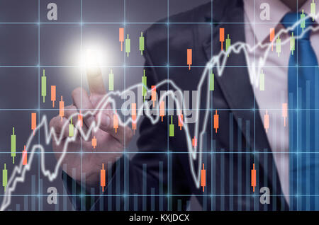 Businessman pointing or touching the trading graph of stock market on the virtual screen on dark background, Business stock market concept Stock Photo