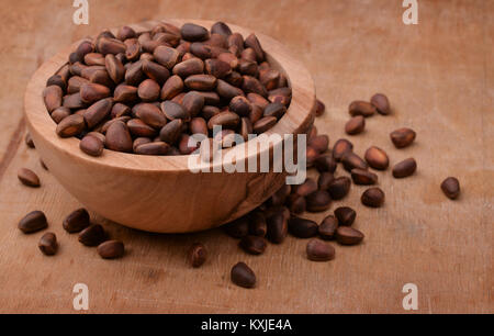 Bowl of cedar nuts on wooden background Stock Photo