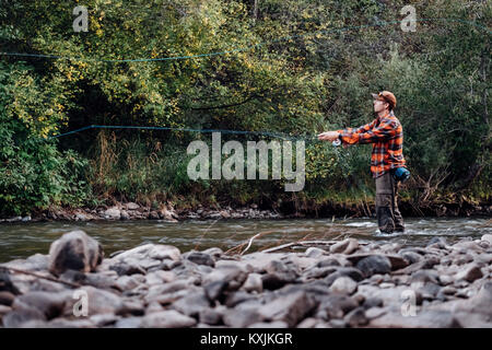 Man wading in river, fishing Stock Photo