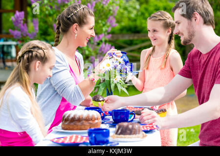 Family having coffee time in garden eating cake Stock Photo