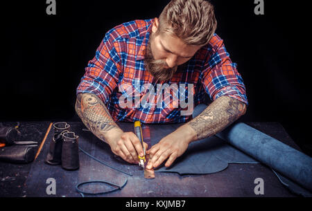 Leather workman working on a new leather product at studio Stock Photo