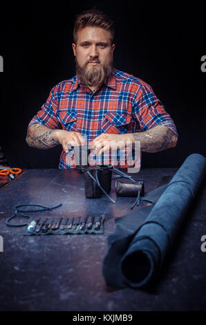 Professional Tanner cuts out leather goods Stock Photo