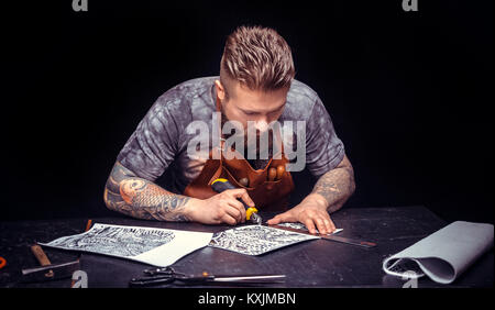 Artist working with leather produce a leatherwork at his tanner shop Stock Photo