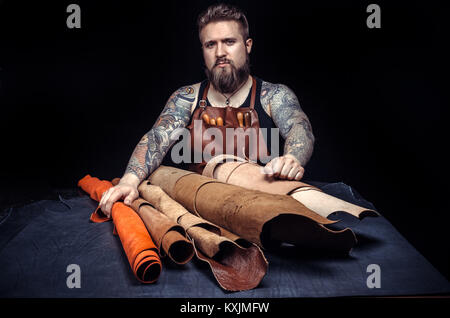Leather cutter works with leather goods in the tanning shop Stock Photo