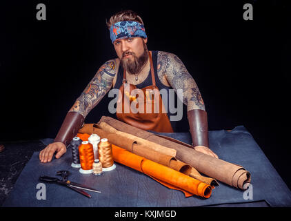 Artisan of leather works with leather at workplace Stock Photo