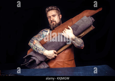 Man working with leather being keen on his buisness Stock Photo