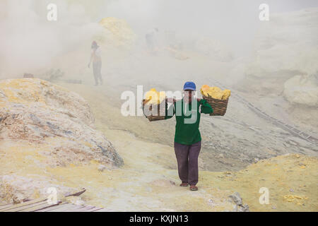 BANYUWANGI, INDONESIA - OCTOBER 27, 2014: Unidentified Sulfur miner inside crater of Ijen volcano, East Java, Indonesia. Stock Photo