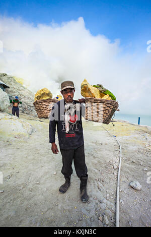 BANYUWANGI, INDONESIA - OCTOBER 27, 2014: Unidentified Sulfur miner inside crater of Ijen volcano, East Java, Indonesia. Stock Photo