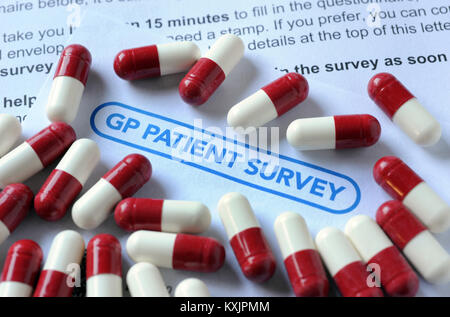GP PATIENT SURVEY FORM WITH MEDICATION CAPSULES RE COST OF HEALTHCARE PRESCRIPTIONS MEDICINE NHS GP DRUGS DOCTORS ETC UK Stock Photo