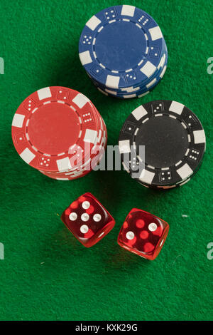 two red dices and different chips on green background. gambling and betting addiction concept Stock Photo