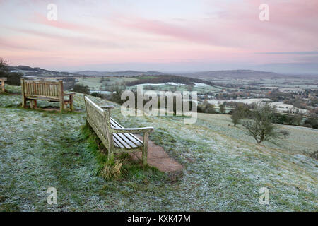 Bench overlooking Broadway village with Bredon Hill and Vale of Evesham on frosty morning Stock Photo