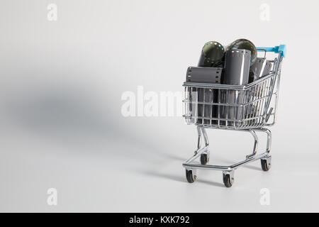 Shopping trolley and tangle of unrolled exposed 35mm film strips over a white background in a retro photography concept Stock Photo