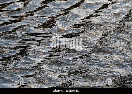 Waves in the surface of the water which result in a specific colour and structure Stock Photo