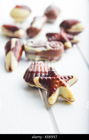 Sweet chocolate seashells on white table. Stock Photo