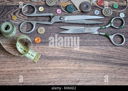 Scissors and buttons on a wooden background Stock Photo