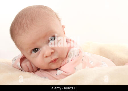 Pretty baby girl laying on soft rug, child safety and welfare, Stock Photo