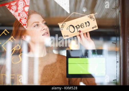 Small business owner turning open sign Stock Photo