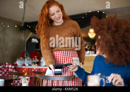 Customer in cafe making contactless payment with mobile phone Stock Photo