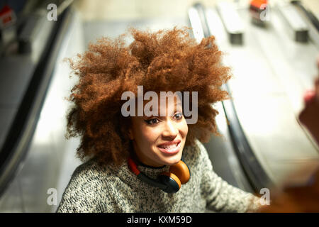 Young woman on escalator,smiling,elevated view Stock Photo