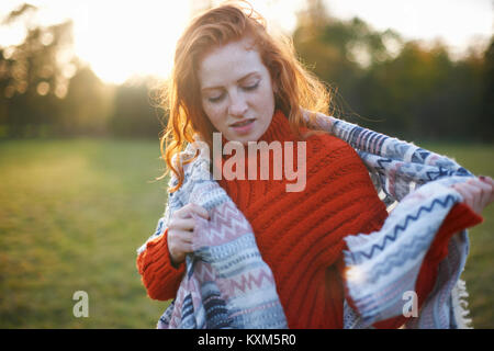 Young woman in rural setting,wrapped in blanket Stock Photo