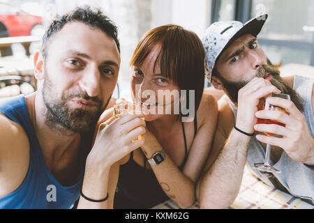 Portrait of three young hipster friends drinking cocktails Stock Photo