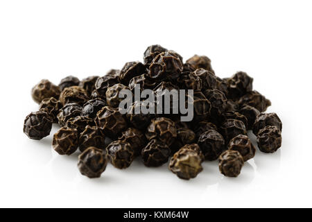 A pile of whole black pepper isolated on white. Stock Photo