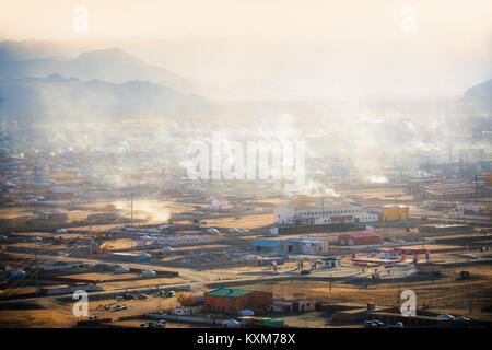 Khovd Hovd town city sunset smoke chimneys burning coal to stay warm and in cold Mongolian winter Stock Photo