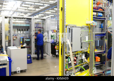 man assembles electronic components on a machine in a factory for mechanical engineering Stock Photo