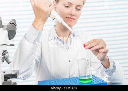 Experiments in the chemical laboratory, Female researcher using her test tube in a laboratory Stock Photo