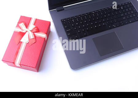 Laptop and christmas gifts box on white desk Stock Photo